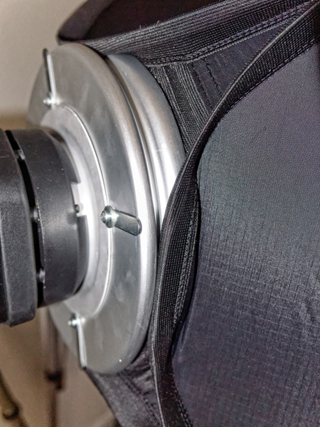 Photograph of Lastolite EZbox 36x36 mounted in the groove of the included mounting plate and adapter ring assembly.